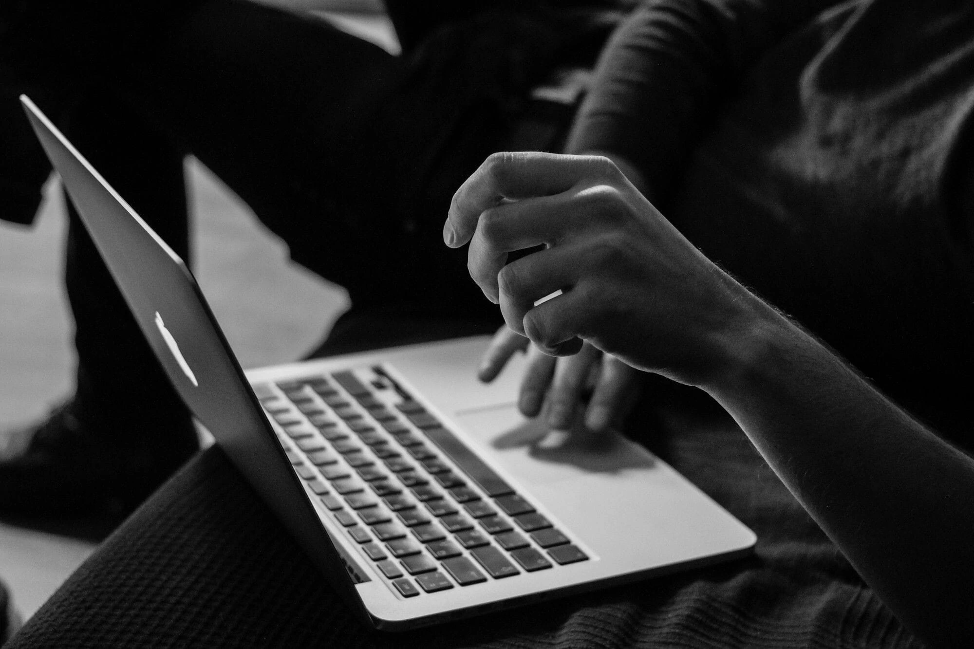 Sort-hvitt bilde av digitalt arbeid og administrasjon på PC som representerer tjenestene til Jova Services.